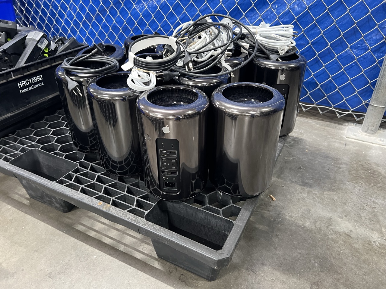 Apple devices on plastic crate with cords stacked on top